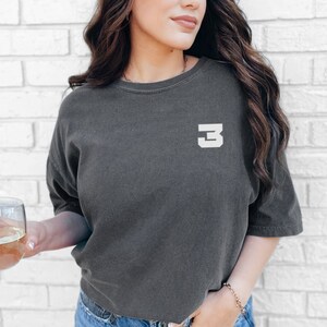 May include: A charcoal gray cropped t-shirt with a white number "3" on the front.