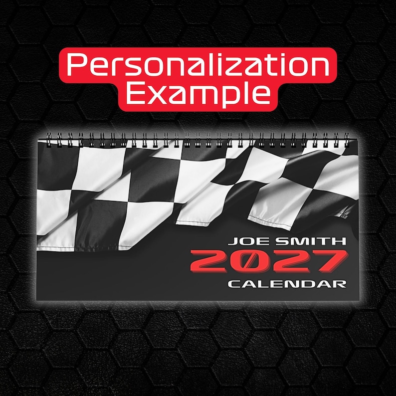 May include: A spiral-bound wall calendar featuring a black and white chequered flag graphic at the top. The text reads Personalization Example, Joe Smith, 2027, and Calendar. The design uses a black background with bold red lettering for the year.