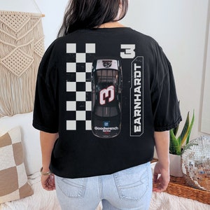 May include: Black t-shirt with a white checkered pattern and a black race car with the number 3 on it. The text "EARNHARDT" is printed vertically on the right side of the shirt.