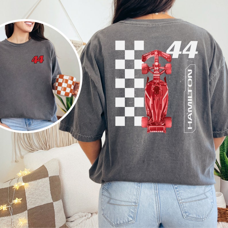K&ouml;nnte beinhalten: Ein graues T-Shirt mit einem roten Rennwagen-Motiv und der Nummer 44 sowie dem Wort HAMILTON auf der R&uuml;ckseite.