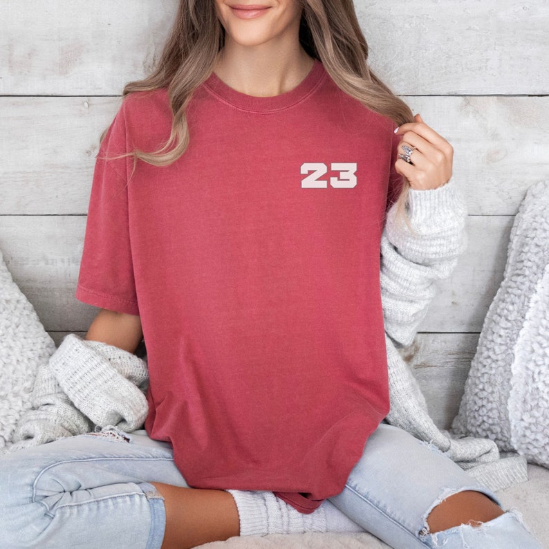 May include: A red t-shirt with the number 23 printed on the front in white.