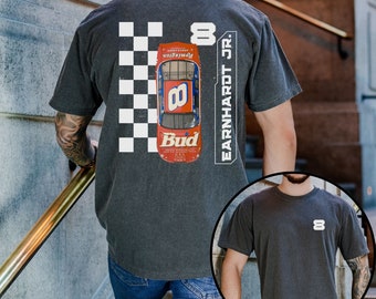 May include: A black t-shirt with a vintage-style image of a race car with the number 8 and the text "Bud" on it. The text "EARNHARDT JR." is on the right side of the image. The t-shirt has a checkered pattern behind the car. A second black t-shirt with the number 8 on the front is shown in the background.