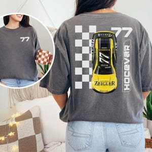 May include: A gray t-shirt with a black and white checkered pattern, a yellow race car with the number 77, and the text "Ziegler" and "Hocevar" printed on the back.