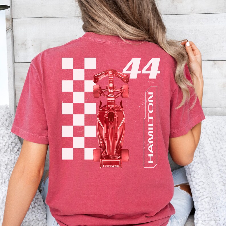 K&ouml;nnte beinhalten: Rotes T-Shirt mit einem wei&szlig;en Karomuster, einem roten Rennwagen und dem Text "44 HAMILTON" auf der R&uuml;ckseite.