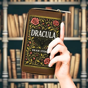 Portafoglio a forma di libro con l'immagine di Dracula, dallo stile gotico vintage, ideale per gli amanti dell'horror e della letteratura.