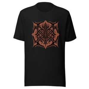 Könnte beinhalten: Schwarzes T-Shirt mit einem braunen und schwarzen geometrischen Design. Das Design zeigt einen zentralen Kreis mit komplizierten Mustern und Symbolen.