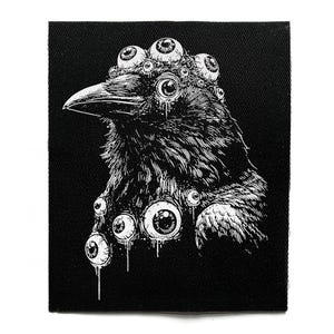 以下が含まれることがあります： 黒と白のパッチ。複数の眼球で飾られたカラスの頭部の詳細なイラスト。カラスは詳細な羽毛と目立つくちばしを持っています。眼球には滴るような効果があり、デザインにユニークなタッチを加えています。