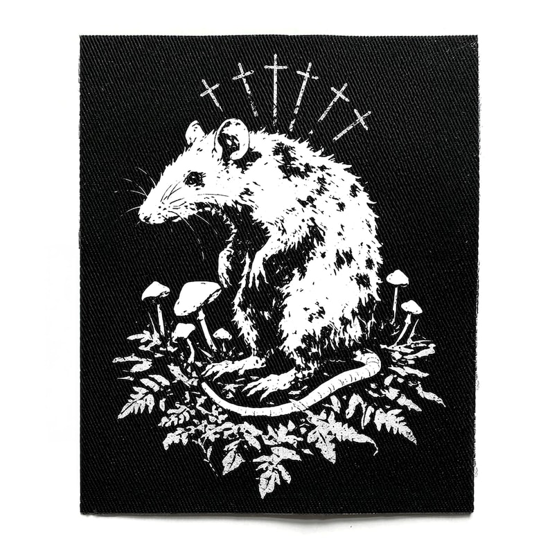 May include: Black and white patch featuring a stylized rat surrounded by mushrooms and foliage. Above the rat are several cross symbols. The patch is square and made of a textured fabric.
