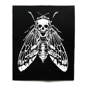May include: Black square patch featuring a white illustration of a cicada with a skull replacing its head. The insect's wings are detailed with intricate patterns. The patch is likely for clothing or accessories.