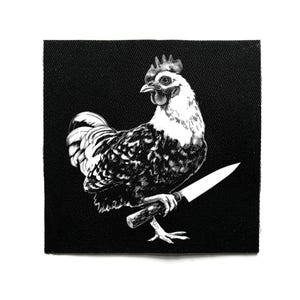 Pode incluir: Patch em preto e branco com uma ilustração detalhada de um galo segurando uma faca. O galo é retratado em um estilo realista com detalhes intrincados de penas. O patch é quadrado e tem um fundo preto.