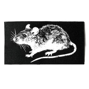 Könnte beinhalten: Ein schwarzer rechteckiger Aufnäher mit einer weißen Illustration einer Maus. Die Maus ist im Profil dargestellt, mit Schnurrhaaren, Ohren und einem langen Schwanz. Das Design ist eine monochrome Grafik.