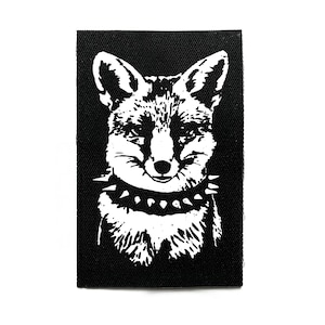 Peut inclure: Écusson rectangulaire noir et blanc avec un renard stylisé. Le renard porte un collier à pointes et présente un design texturé. Parfait pour personnaliser vêtements et accessoires.