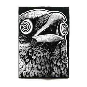 Puede incluir: Parche en blanco y negro con una ilustración detallada de la cabeza de un pájaro con el pico abierto y ojos en espiral. Las plumas del pájaro están intrincadamente dibujadas, sobre un fondo negro.