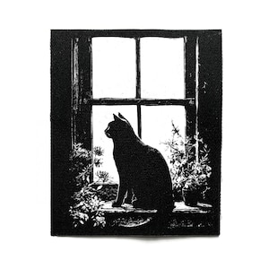 Puede incluir: Parche en blanco y negro con la silueta de un gato sentado en un alféizar, mirando hacia afuera. La ventana está dividida en paneles, con plantas en macetas y en el alféizar. El parche tiene una apariencia texturizada.