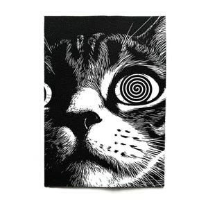 Può includere: Toppa in bianco e nero raffigurante il volto di un gatto con un disegno a spirale in un occhio. Il pelo del gatto è dettagliato con linee sottili e la toppa ha una forma rettangolare.