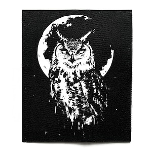 May include: Black and white patch featuring an owl with a full moon backdrop. The owl is detailed with intricate feather patterns, and the moon has a textured appearance. The design is set against a solid black background, creating a striking contrast.