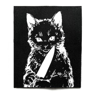 Peut inclure: Écusson noir et blanc représentant un chat tenant un couteau. Le chat est représenté dans une illustration stylisée et détaillée avec de grands yeux et une expression menaçante. L'écusson a un fond noir.