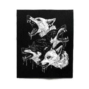Könnte beinhalten: Schwarz-weißer Aufnäher mit einer detaillierten Illustration von vier knurrenden Wölfen mit offenem Maul und tropfendem Speichel. Die Wölfe sind in einem detaillierten, grafischen Stil vor einem schwarzen Hintergrund dargestellt.
