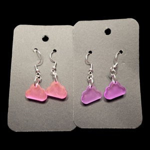 May include: Two pairs of earrings with cloud-shaped charms. One pair is pink and the other is purple.