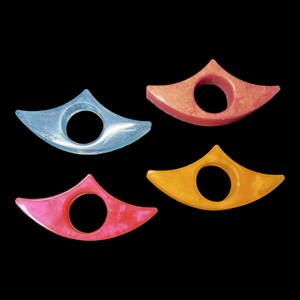 May include: Four colorful bookmark holders in the shape of a crescent moon. The bookmarks are made of resin and have a glossy finish. The colors are light blue, pink, orange, and red.
