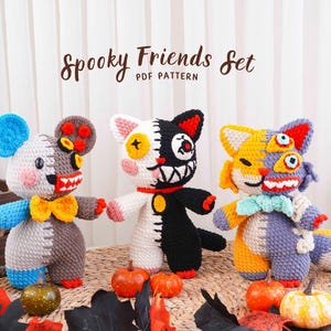 May include: A set of three crocheted plush toys titled Spooky Friends Set PDF Pattern. The toys feature patchwork designs in blue, gray, white, black, orange, and yellow with button eyes, stitched mouths, and colorful bow ties.
