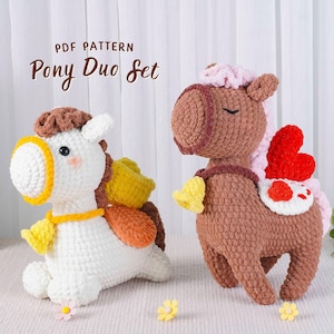 May include: Two crocheted pony figures. One is white with brown and yellow accents, the other is brown with pink and red accents. Both have bells and are part of the "Pony Duo Set" pattern.