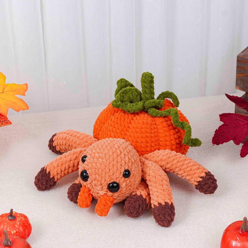 May include: A handmade crochet spider with orange and brown details, paired with an orange pumpkin. The spider has eight legs and black eyes. The pumpkin has green vines and a stem. Perfect for Halloween decor.