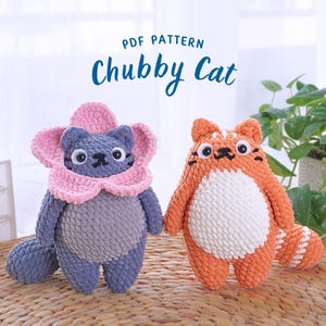 May include: Two crocheted cat toys, one gray with a pink flower on its head and one orange with a white belly.  The toys are sitting on a woven surface.  PDF PATTERN Chubby Cat.