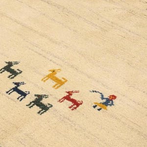 May include: Cream-colored rug with a striped pattern and a dark blue border. The rug features colorful embroidered animal figures in green, yellow, red, and blue. The rug is a decorative floor covering.