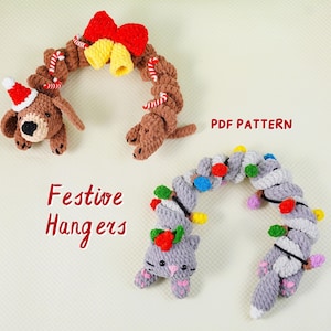 Puede incluir: Perchas festivas de ganchillo con forma de perro, gato y guirnalda de luces. La percha de perro tiene un gorro de Papá Noel y el gato tiene un lazo rojo. El texto "Festive Hangers" y "PDF Pattern" son visibles.