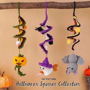 May include: Three crocheted Halloween spinners hanging from a branch. The left features a green spiral with a pumpkin, the center a purple spiral with a ghost in a witch hat, and the right a black and orange spiral with a gray bat. Text reads: PDF PATTERN Halloween Spinner Collection.