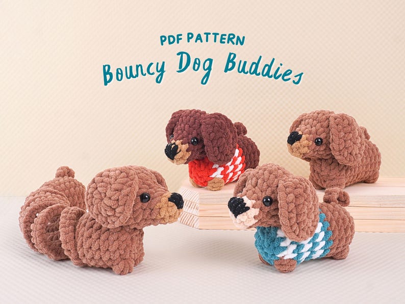 Puede incluir: Cuatro peluches de perro de crochet de color marr&oacute;n con jers&eacute;is de diferentes colores. Los peluches est&aacute;n sentados sobre una superficie de madera. El texto "PDF PATTERN Bouncy Dog Buddies" est&aacute; en la parte superior de la imagen.