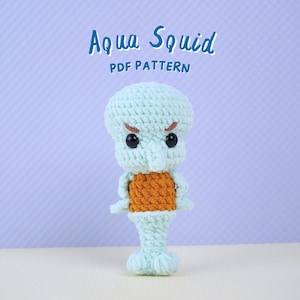 May include: A crocheted amigurumi toy of Squidward Tentacles from the cartoon Spongebob Squarepants. The toy is light blue with orange clothing and black eyes. The toy is standing on a white surface. The text "Aqua Squid PDF Pattern" is above the toy.