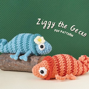 Könnte beinhalten: Zwei gehäkelte Gecko-Spielzeuge, eines in Blau und eines in Orange, mit weißen und gelben Blumenakzenten. Die Geckos liegen auf einem Holzstück. Der Text "Ziggy the Gecko PDF Pattern" ist in weißer Schrift geschrieben.