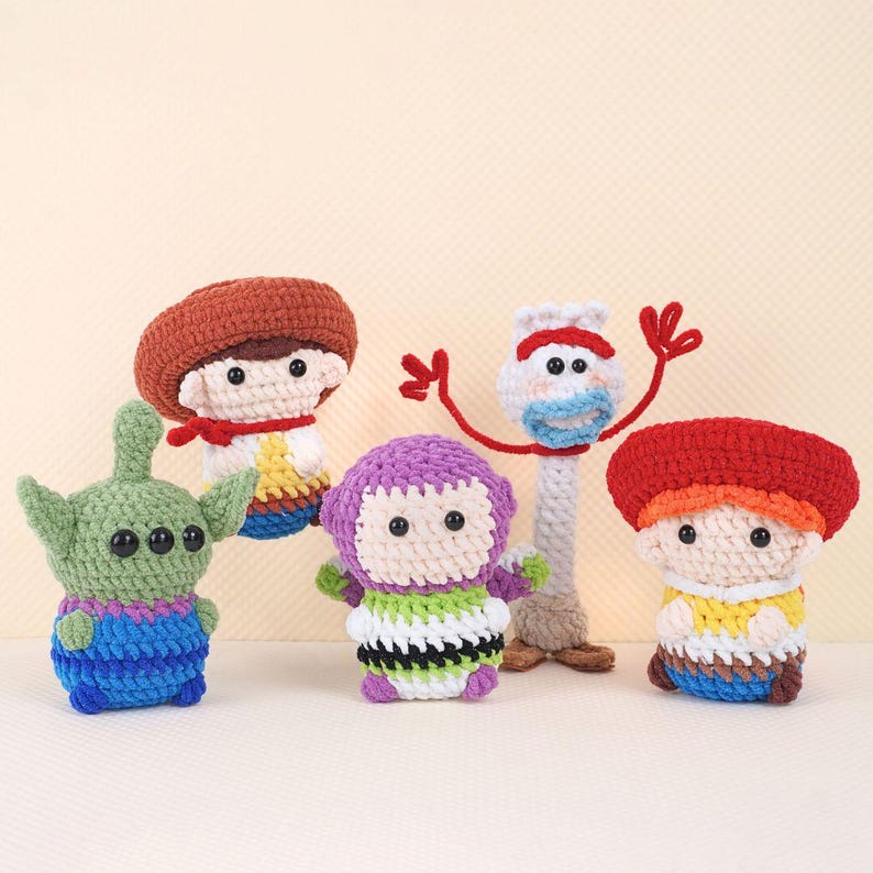 May include: Five crocheted plush toys inspired by the characters from the Toy Story movie franchise. The toys include Woody, Buzz Lightyear, Jessie, Rex, and Alien. The toys are all handmade and have a cute, cartoonish style.