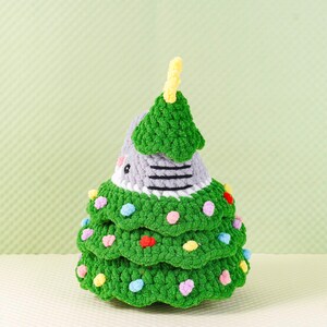 Peut inclure: Un sapin de No&euml;l au crochet fait &agrave; la main, vert, gris et blanc. L'arbre est d&eacute;cor&eacute; de pois color&eacute;s et d'un sommet jaune. L'arbre mesure environ 15 cm de haut.