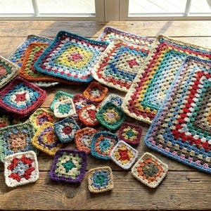 May include: A collection of colorful, handmade crochet squares and larger pieces in various sizes. The squares feature intricate patterns and a variety of colors, including red, blue, green, and yellow. They are arranged on a rustic wooden surface.