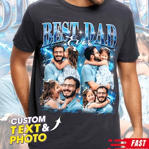 May include: Dark gray t-shirt with the text "BEST DAD Ever" in a blue, stylized font. The shirt features a collage of photos of a man and a child. The words "CUSTOM TEXT & PHOTO" are also visible.