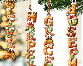 May include: Gingerbread-style Christmas ornaments spelling out names: Olivia, Harper, Grace, and Joseph. Each letter is decorated with white icing, red, green, and white accents, and hung from a gold string. Festive holiday decor.