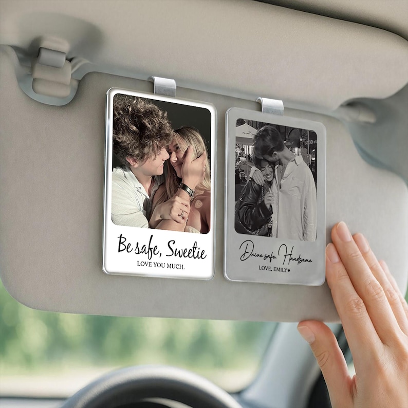 May include: Two clear, rectangular car visor photo holders with photos of couples. One has the text "Be safe, Sweetie" and "LOVE YOU MUCH." The other says "Drive safe Handsome" and "LOVE, EMILY."