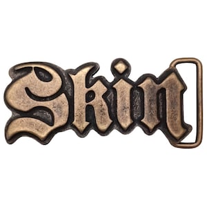 Puede incluir: Una hebilla de cinturón dorada con la palabra "Skin" en una fuente gótica.