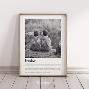 May include: Black and white framed print featuring two children with their arms around each other. The word "brother" is at the bottom, along with a definition. The children are wearing striped shirts and overalls.
