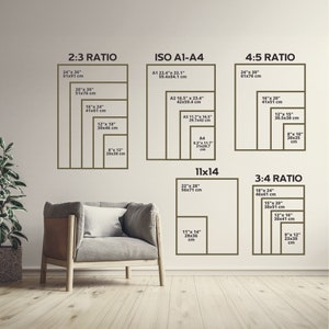 May include: A wall display showcasing various print sizes and ratios, including 2:3, ISO A1-A4, 4:5, 11x14, and 3:4. Each ratio is labeled with dimensions in inches and centimeters. A modern armchair and a plant are in the foreground.