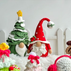 May include: A collection of crocheted Christmas ornaments, including a green Christmas tree, a red gnome, a white reindeer, and a white snowman. The ornaments are all handmade and feature intricate details.