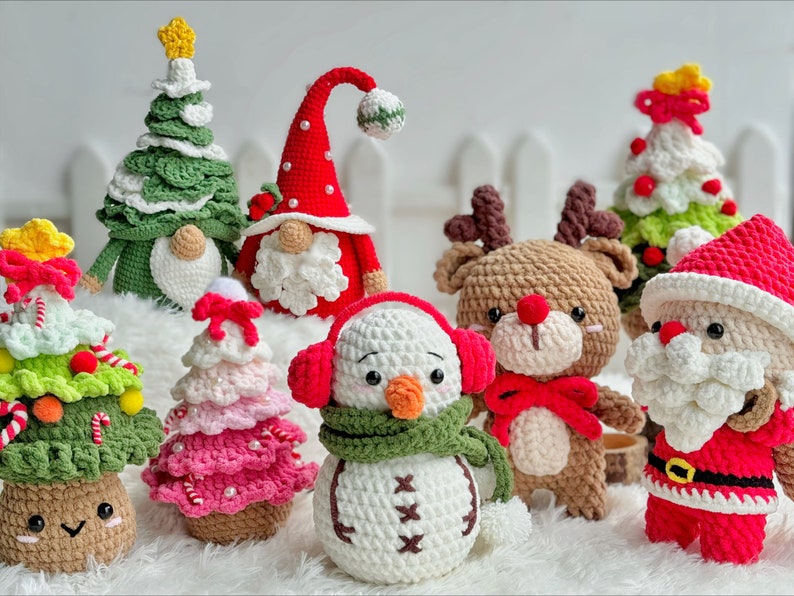 May include: A collection of crocheted Christmas ornaments, including a snowman, reindeer, Santa Claus, and several Christmas trees. The ornaments are made with a variety of colors, including red, green, white, and brown.