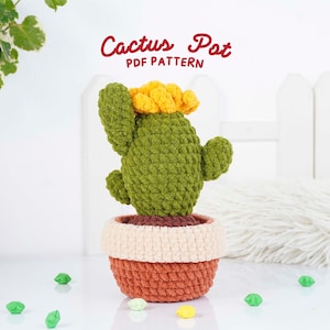 May include: A crocheted cactus plant with a yellow flower, in a two-tone pot. The pot is orange and cream-colored. The text "Cactus Pot PDF Pattern" is in red script above the cactus.