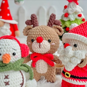 May include: A set of crocheted Christmas ornaments featuring a snowman with a green scarf and red earmuffs, a reindeer with red antlers and a red bow, and Santa Claus with a white beard and red hat.