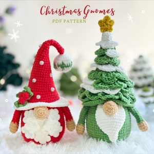 Puede incluir: Dos adornos de gnomo de Navidad hechos a crochet. Un gnomo está vestido de rojo con barba blanca y una rama de acebo verde. El otro gnomo está vestido de verde con barba blanca y una estrella blanca en la parte superior de su gorro. Los gnomos están sentados sobre una superficie blanca y esponjosa.  Patrón PDF de Gnomos de Navidad.