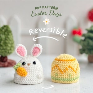 Peut inclure: Patron de crochet pour un lapin et un œuf de Pâques réversibles. Le lapin est blanc avec des oreilles roses et tient une carotte. L'œuf est jaune avec des détails verts et orange. Le motif s'appelle "Easter Days".