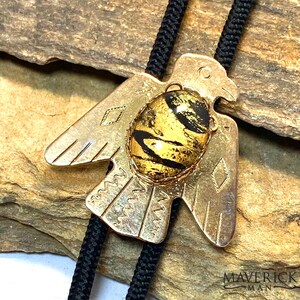 Small golden thunderbird bolo tie with gold and black hand painted stone